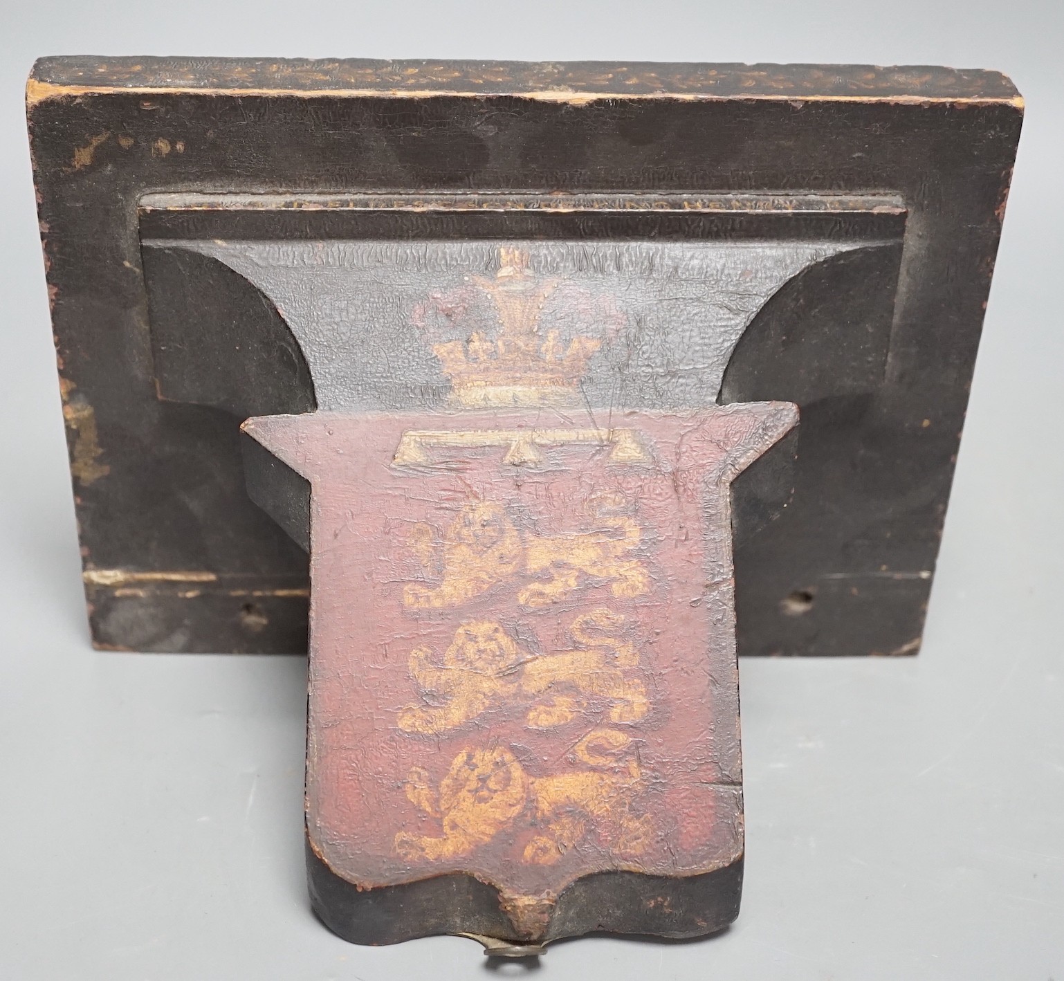 Four 19th century painted and ebonised heraldic wall brackets together with a 19th century armorial plaque